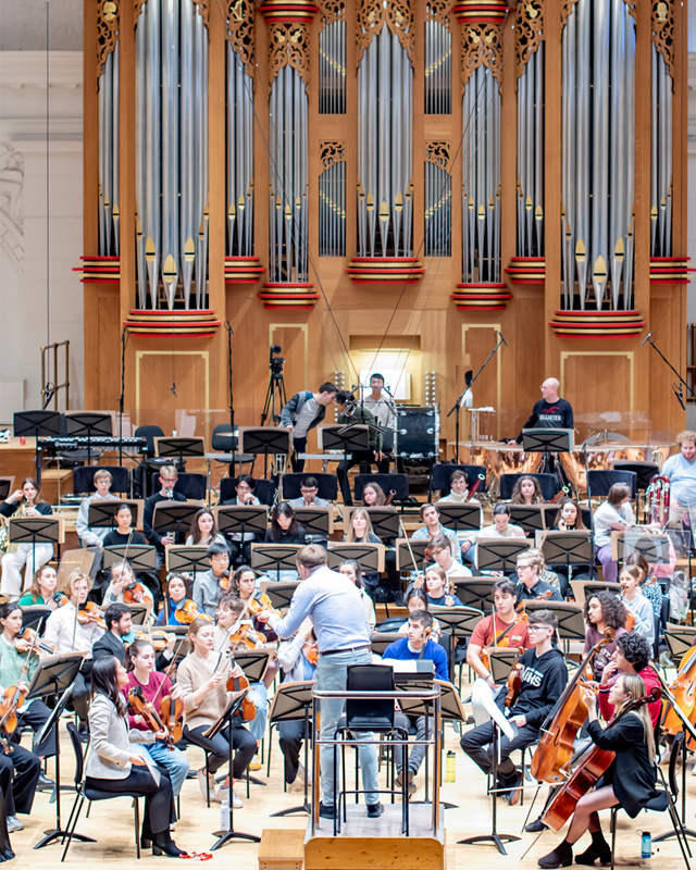 Vasily Petrenko conducting an orchestra with an organ in the background.